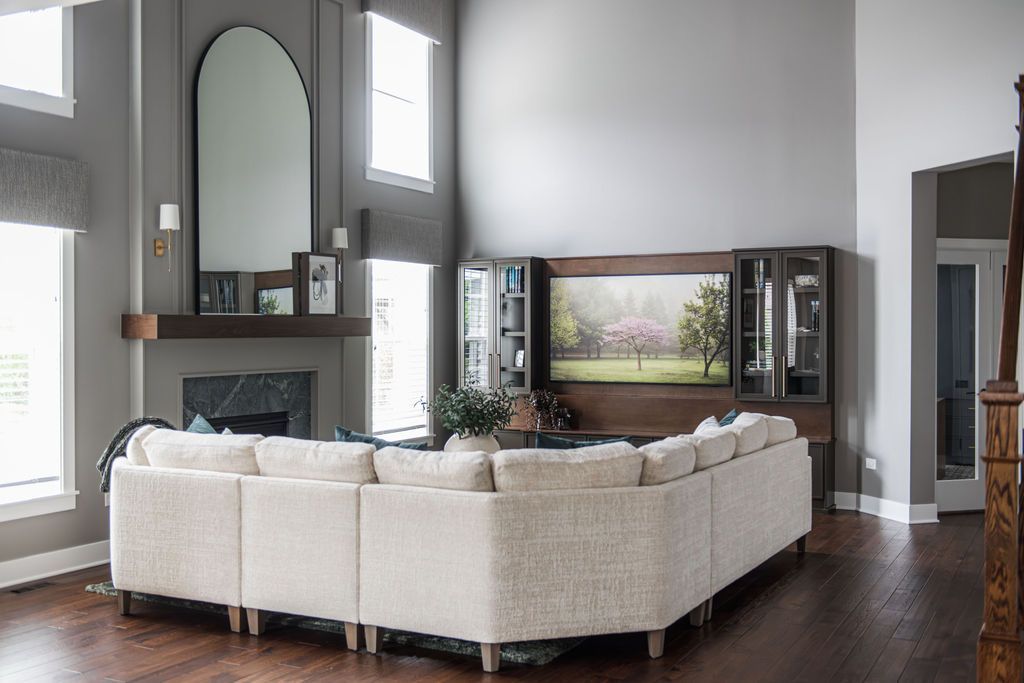 Bright modern living room with a white sectional sofa, fireplace, and large wall art