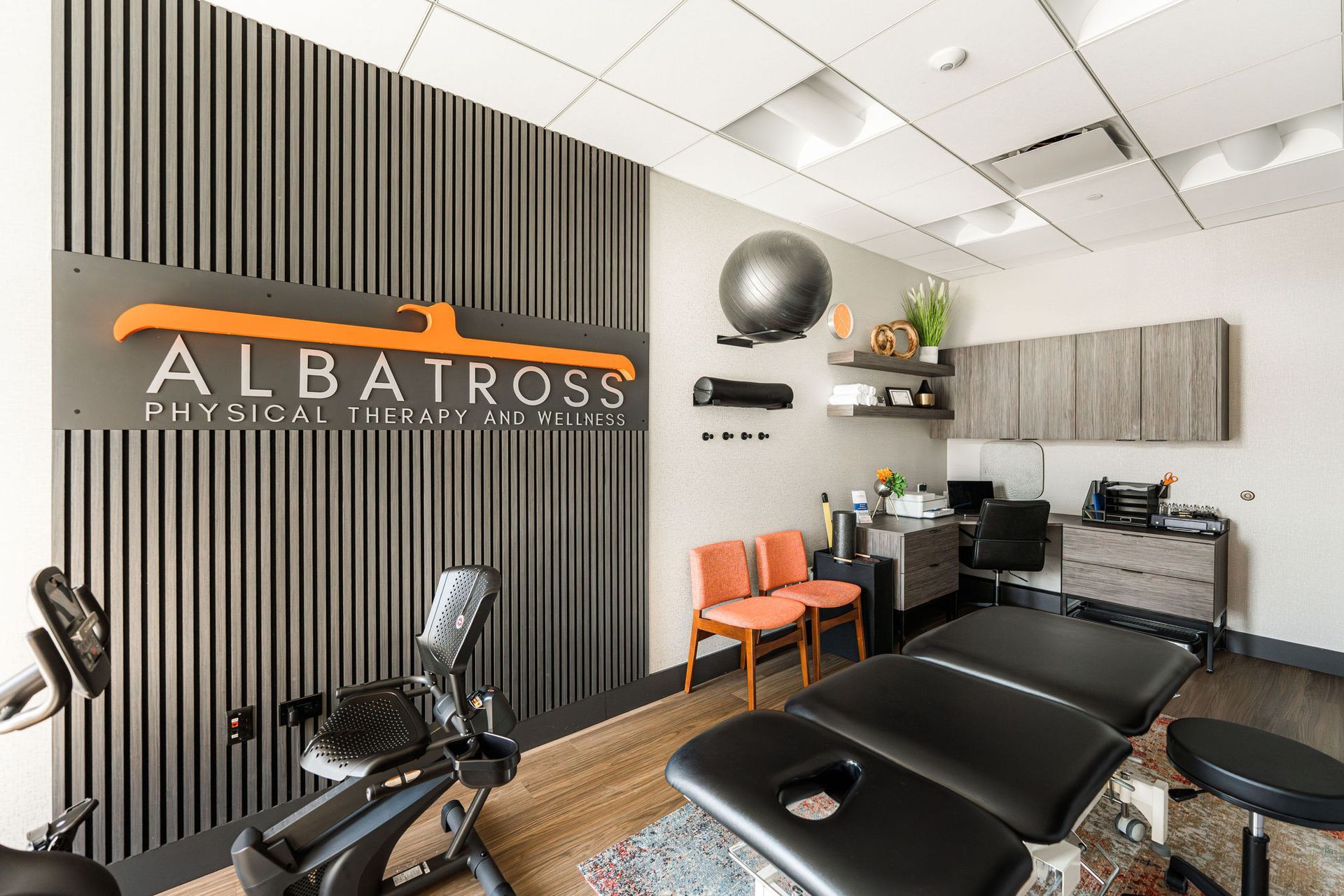 Interior of physical therapy office with equipment and logo.