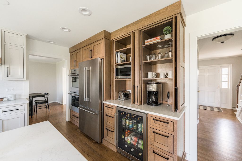 Kitchen with built-in cabinetry, stainless steel fridge, microwave, coffee maker, and drink cooler.