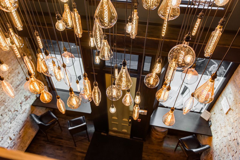 Overhead shot of a room with many glowing Edison bulb pendants hanging from the ceiling.