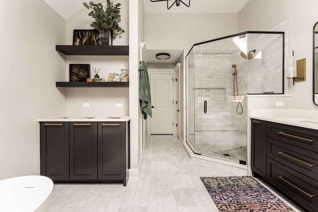 Modern bathroom with dark cabinets, open shower, and floating shelves with decor.