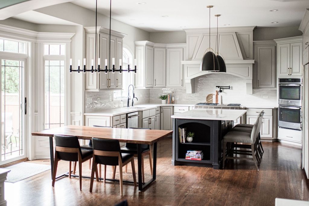 Modern kitchen with light gray cabinets, island, and dining table.