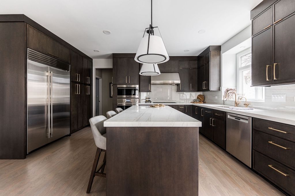Modern kitchen with dark cabinetry, stainless steel appliances, and a central island.