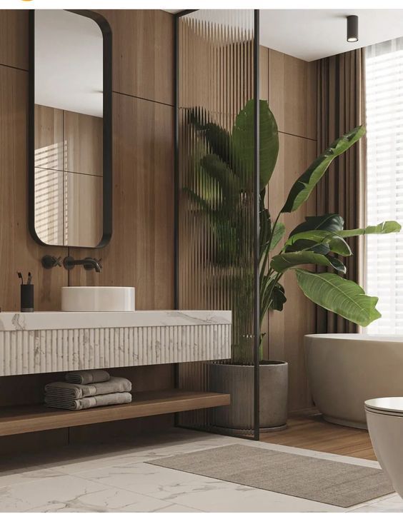 Bathroom with wood paneling, a marble vanity, a large houseplant, and a freestanding bathtub.