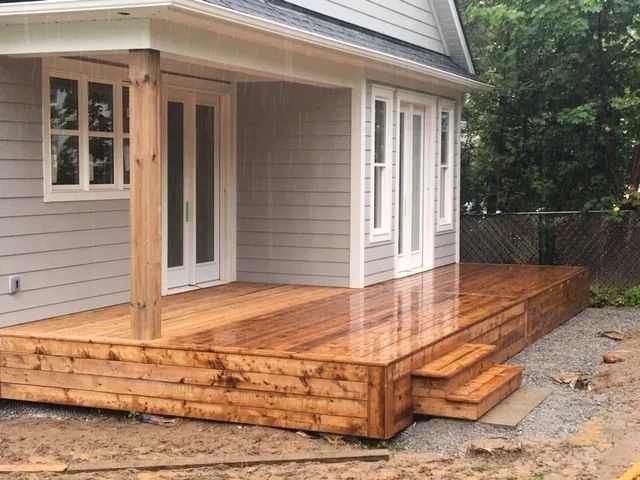 A wooden deck is being built on the side of a house.