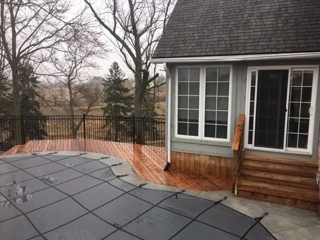 A house with a deck and a pool in front of it