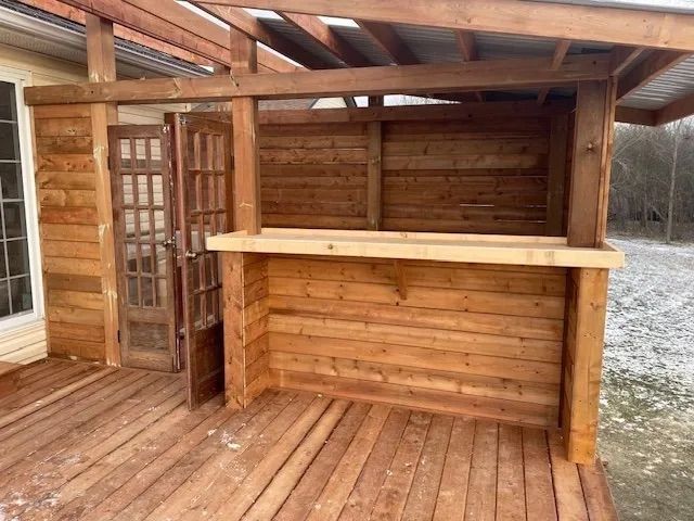 A wooden deck with a wooden bar underneath it