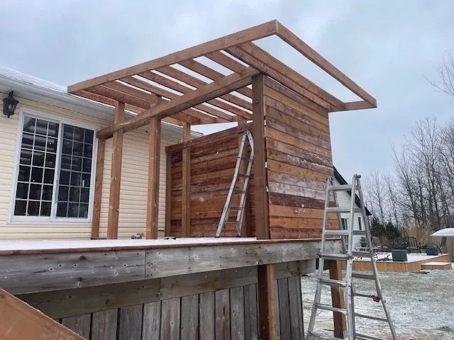 A wooden structure is being built on the side of a house.