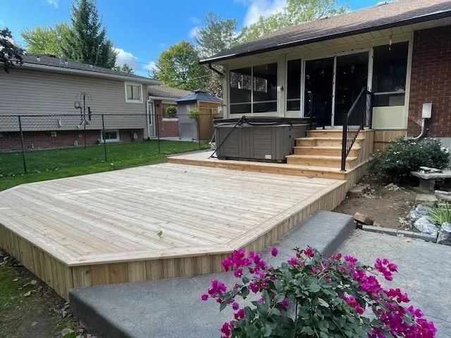 A wooden deck with a hot tub in the backyard of a house.