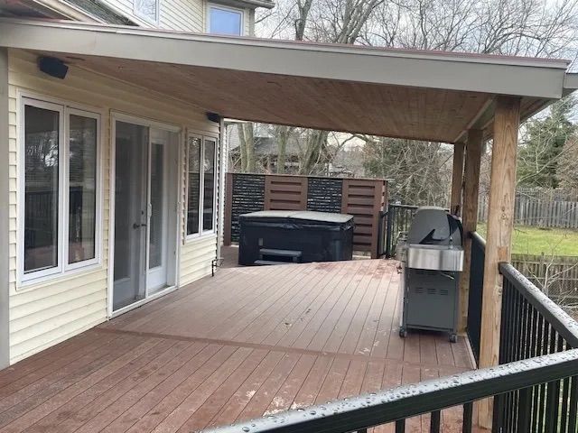 There is a hot tub on the deck of a house.