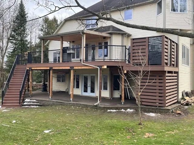 The back of a house with a large deck and stairs.