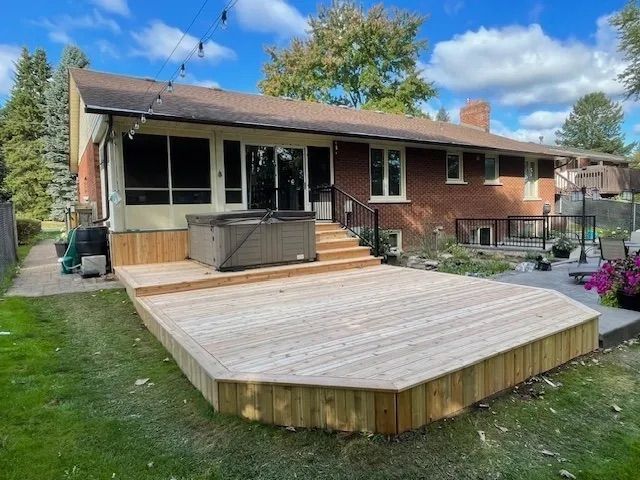 A house with a large wooden deck in front of it.