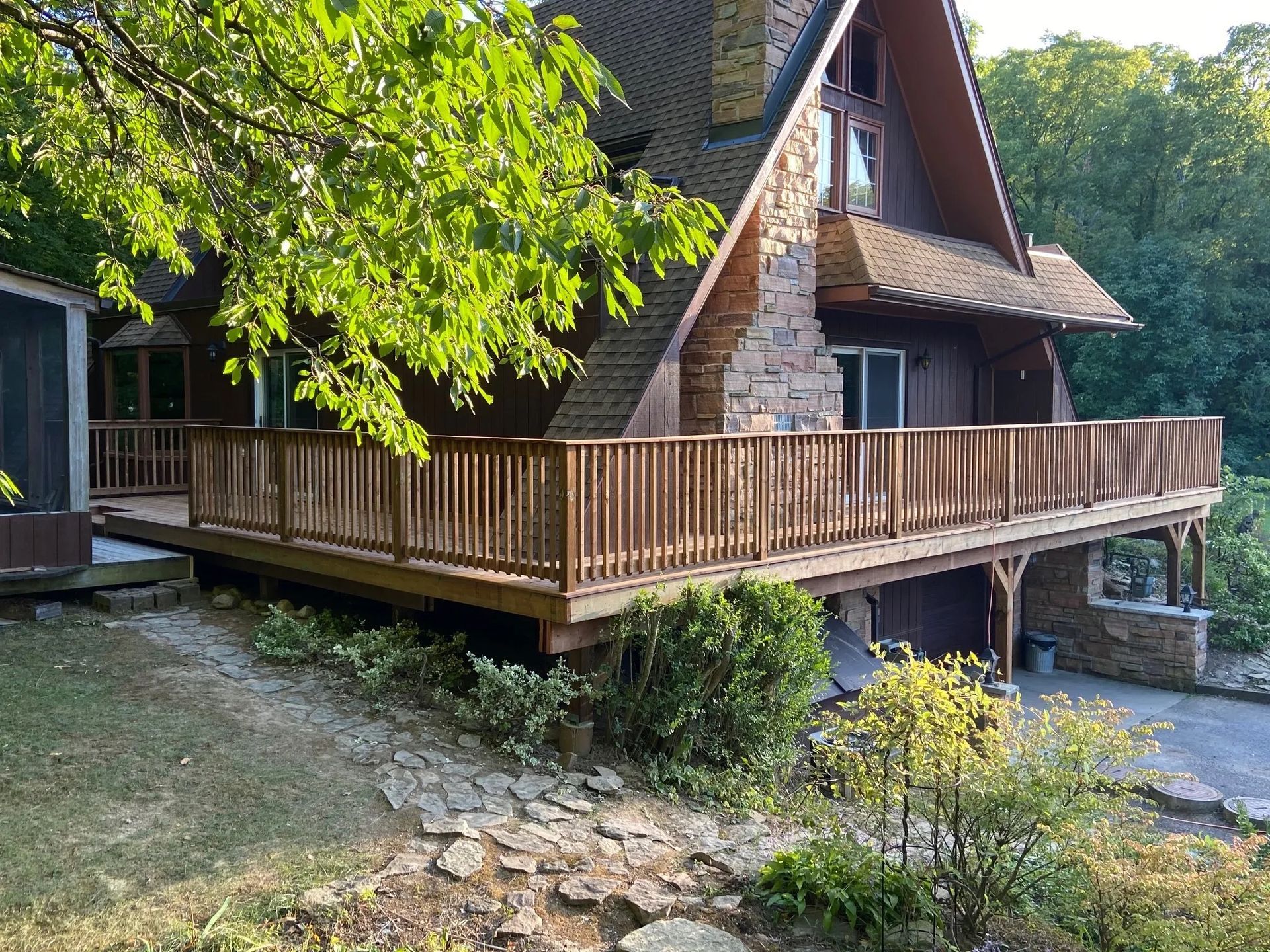 A large house with a large wooden deck in front of it.
