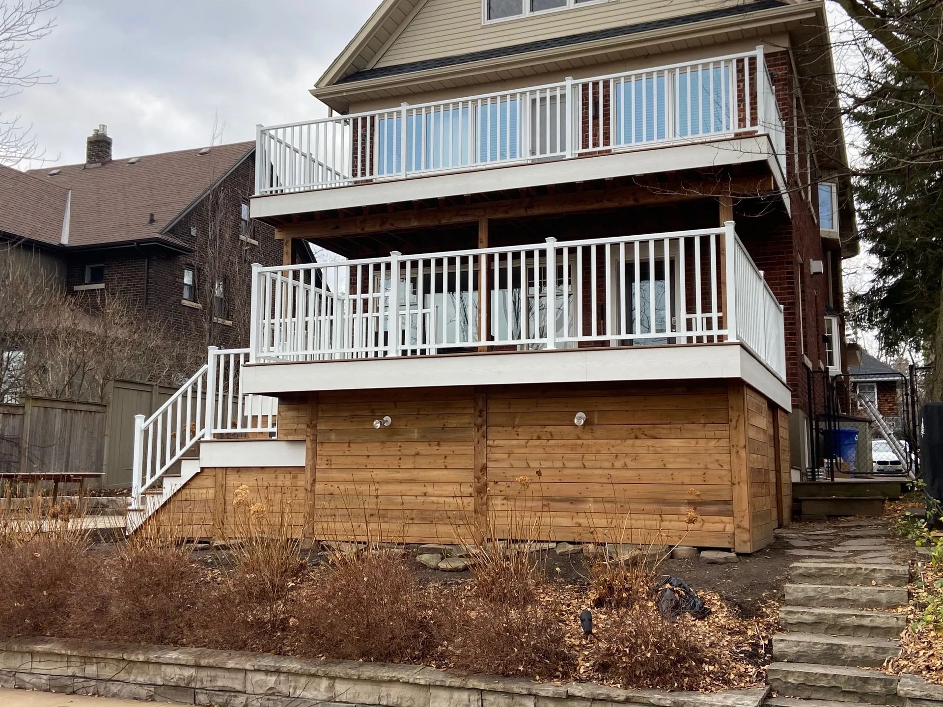 A large house with a large deck and stairs leading up to it.