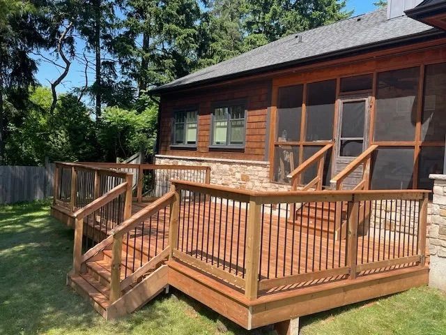 A house with a screened in porch and a wooden deck