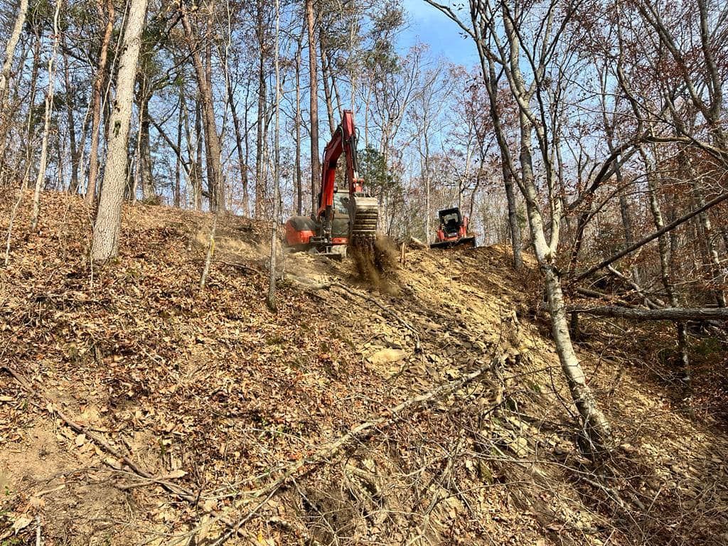 An excavator is digging a hole in the middle of a forest.