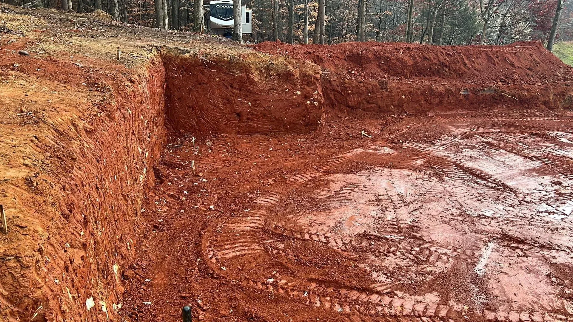 A large pile of dirt is sitting in the middle of a muddy field.