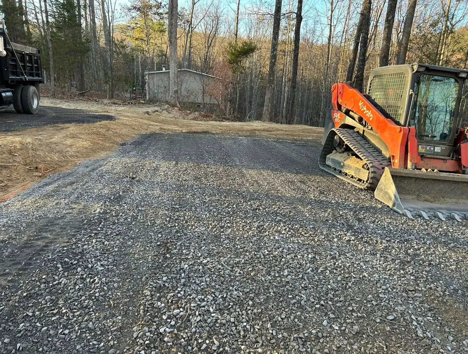 A bulldozer is sitting on top of a gravel road.