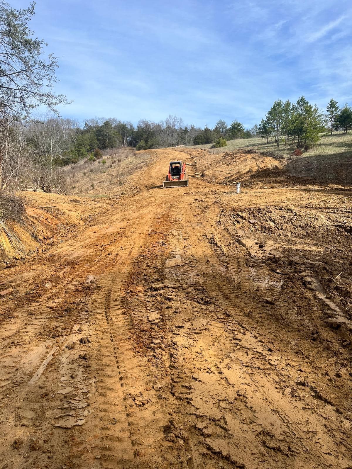 A bulldozer is driving down a dirt road.