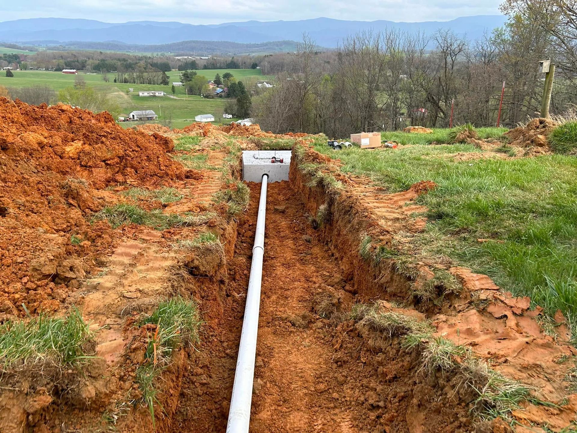 A pipe is being installed in a trench in the dirt.