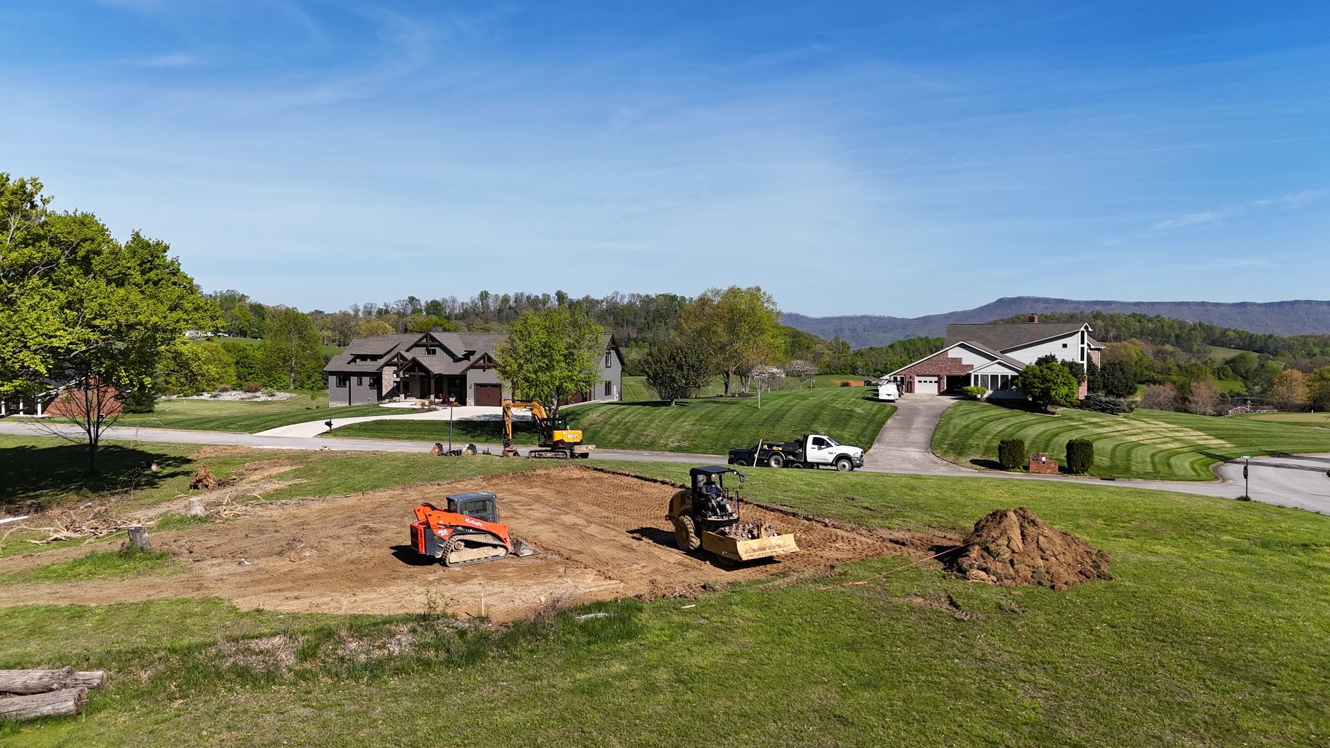 An aerial view of a construction site with a house in the background.