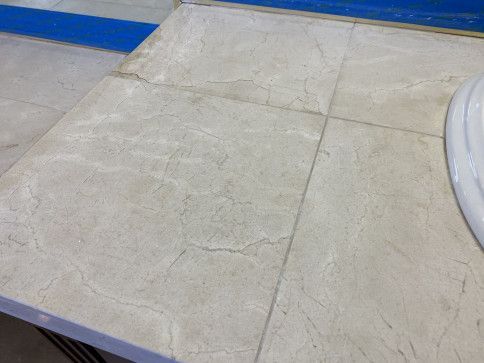 A bathroom counter with a sink and tiles on it.