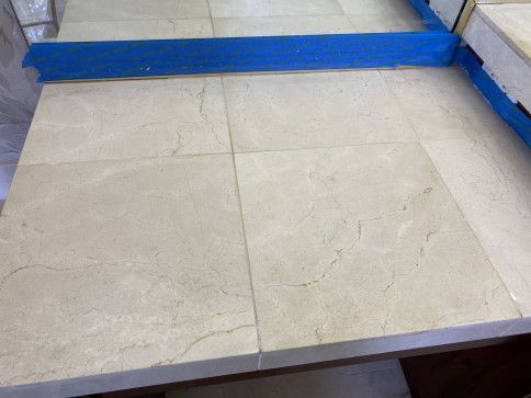 A bathroom counter top with tiles and a mirror.