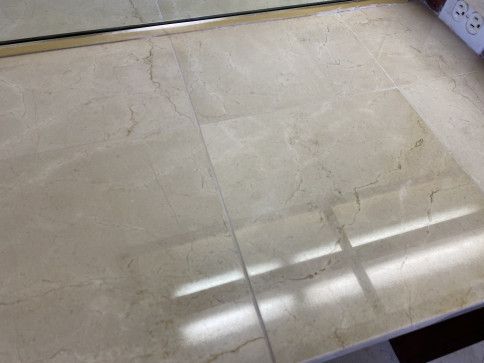 A close up of a marble floor next to a mirror.