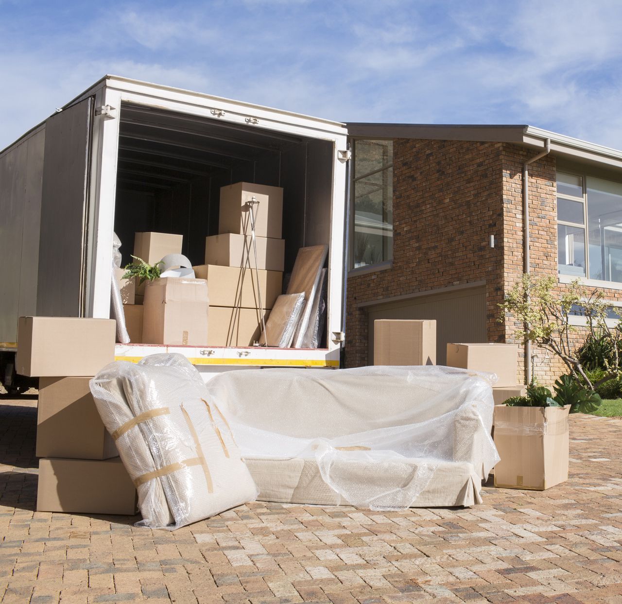 A moving truck is full of boxes and a couch