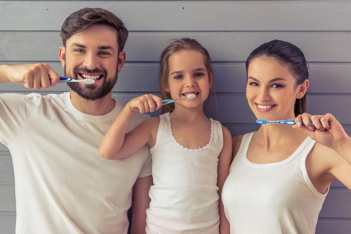 A Family Holding A Toothbrush