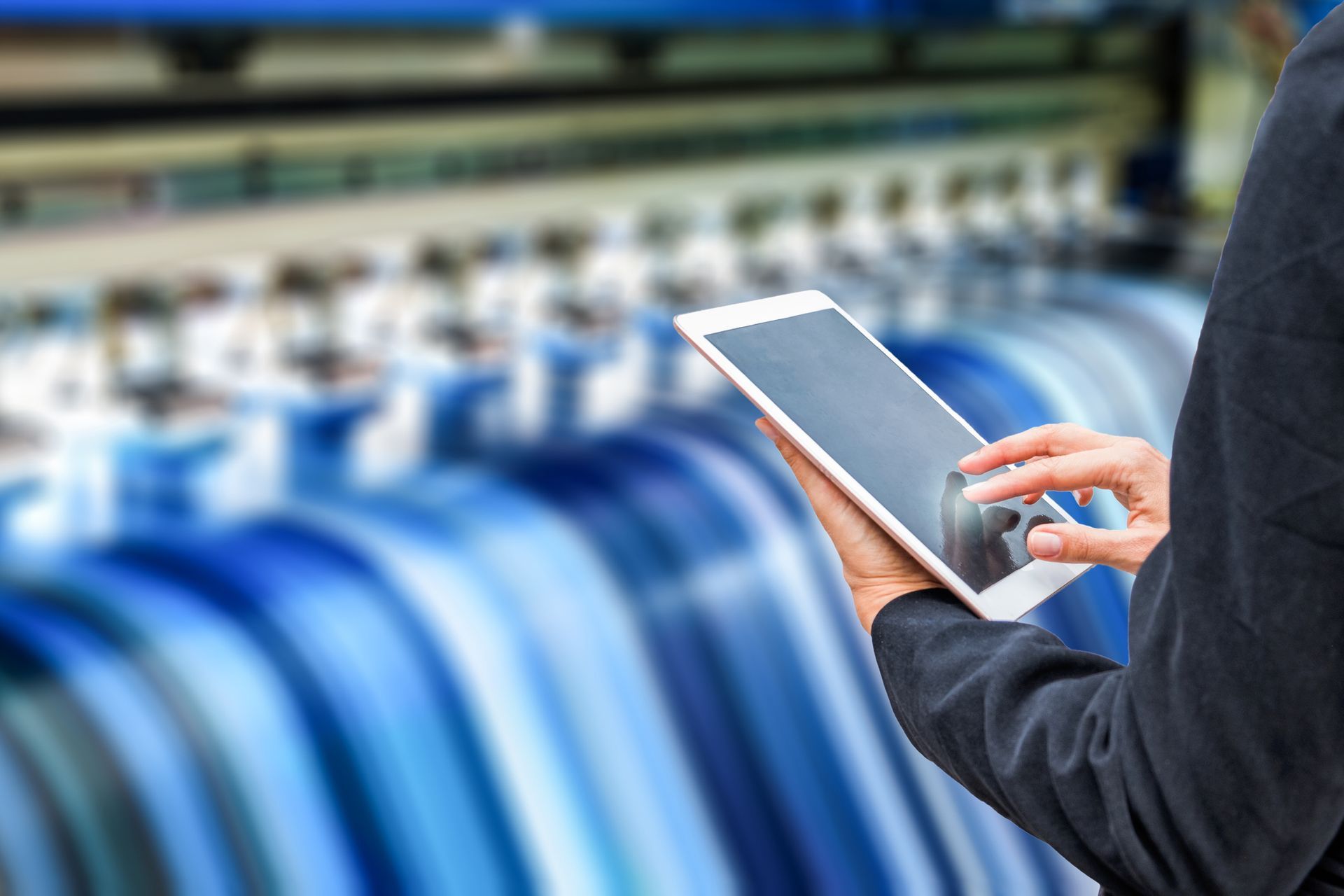 A Person Is Holding A Tablet In Front Of A Printing Machine — Elmira, NY — Rainbow Lettering