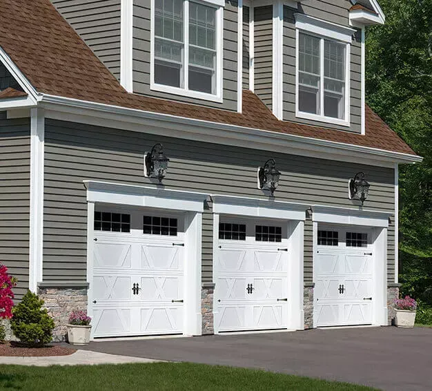 A house with two garage doors and a brick wall