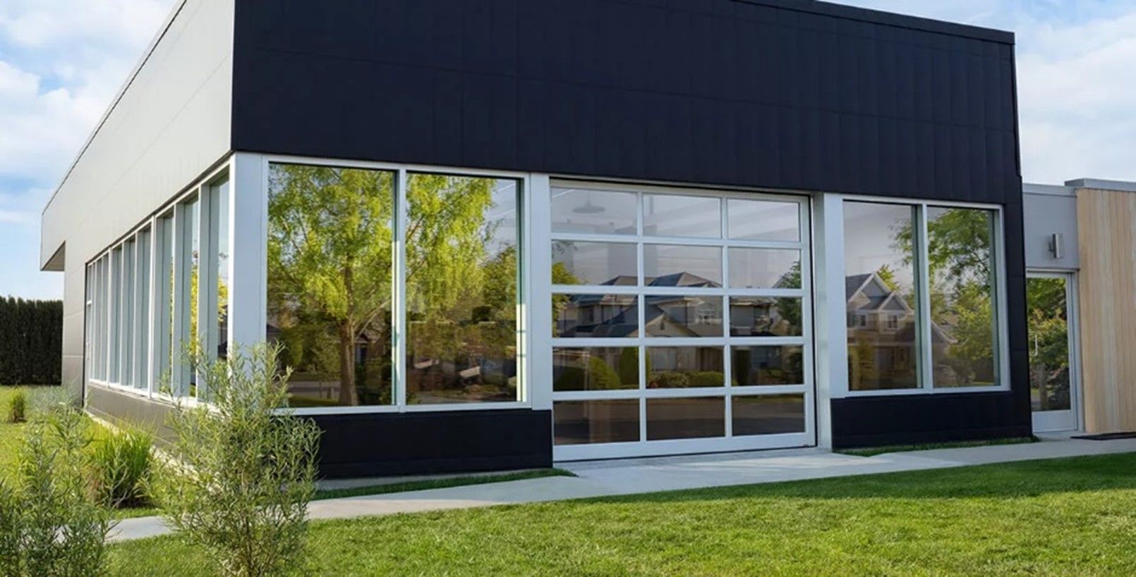A white garage door is open next to a pile of logs.
