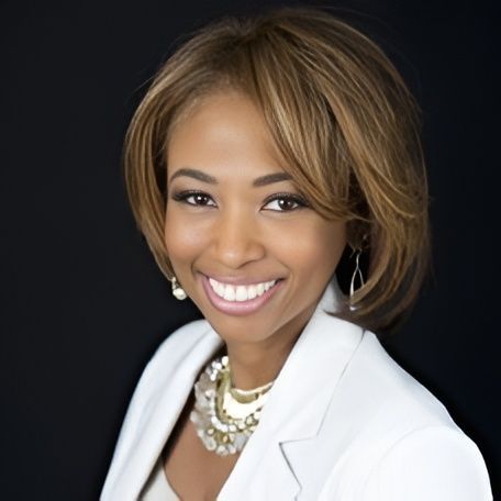 A man wearing glasses and a blue shirt is smiling for the camera.