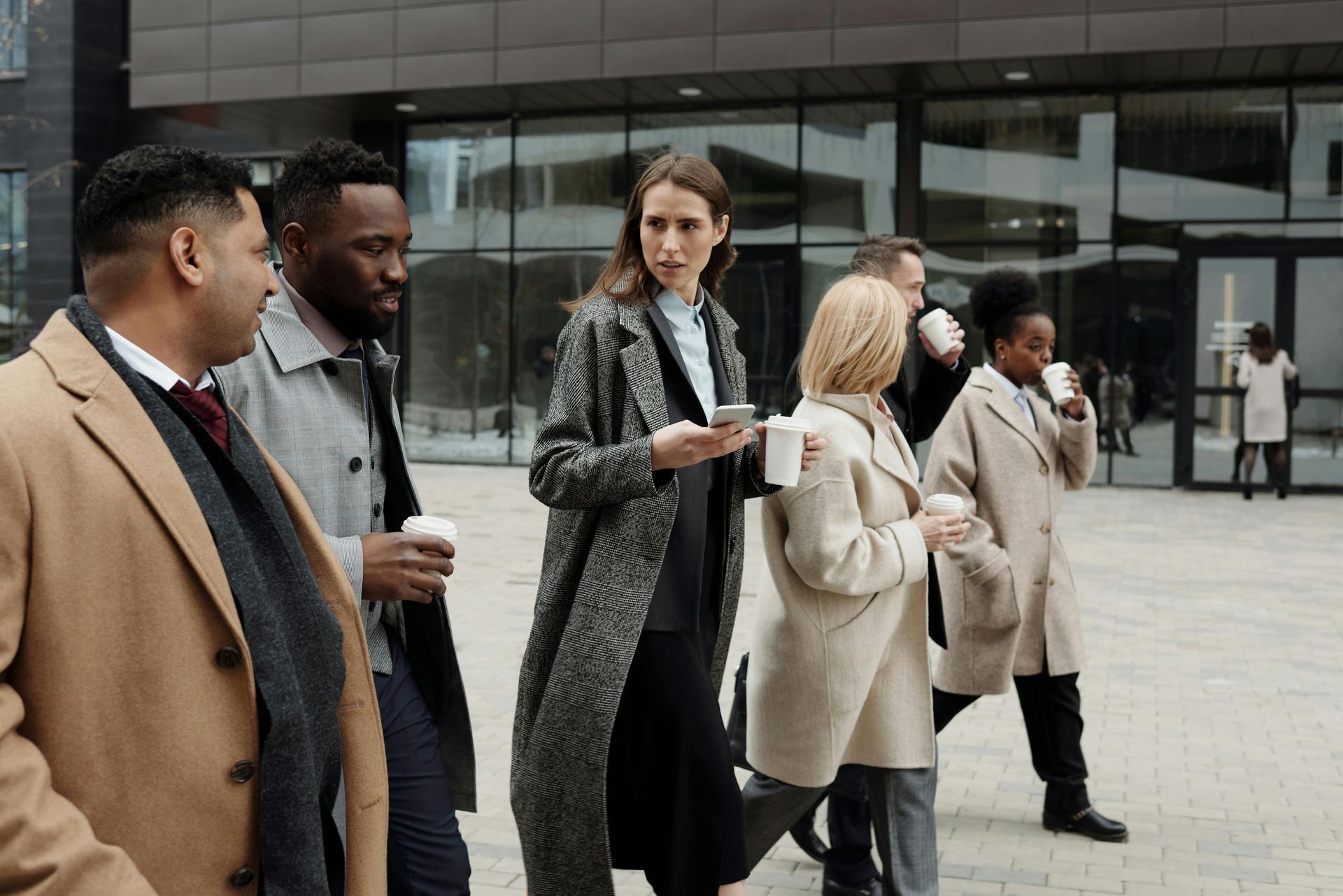 A woman is drinking a cup of coffee in a park.