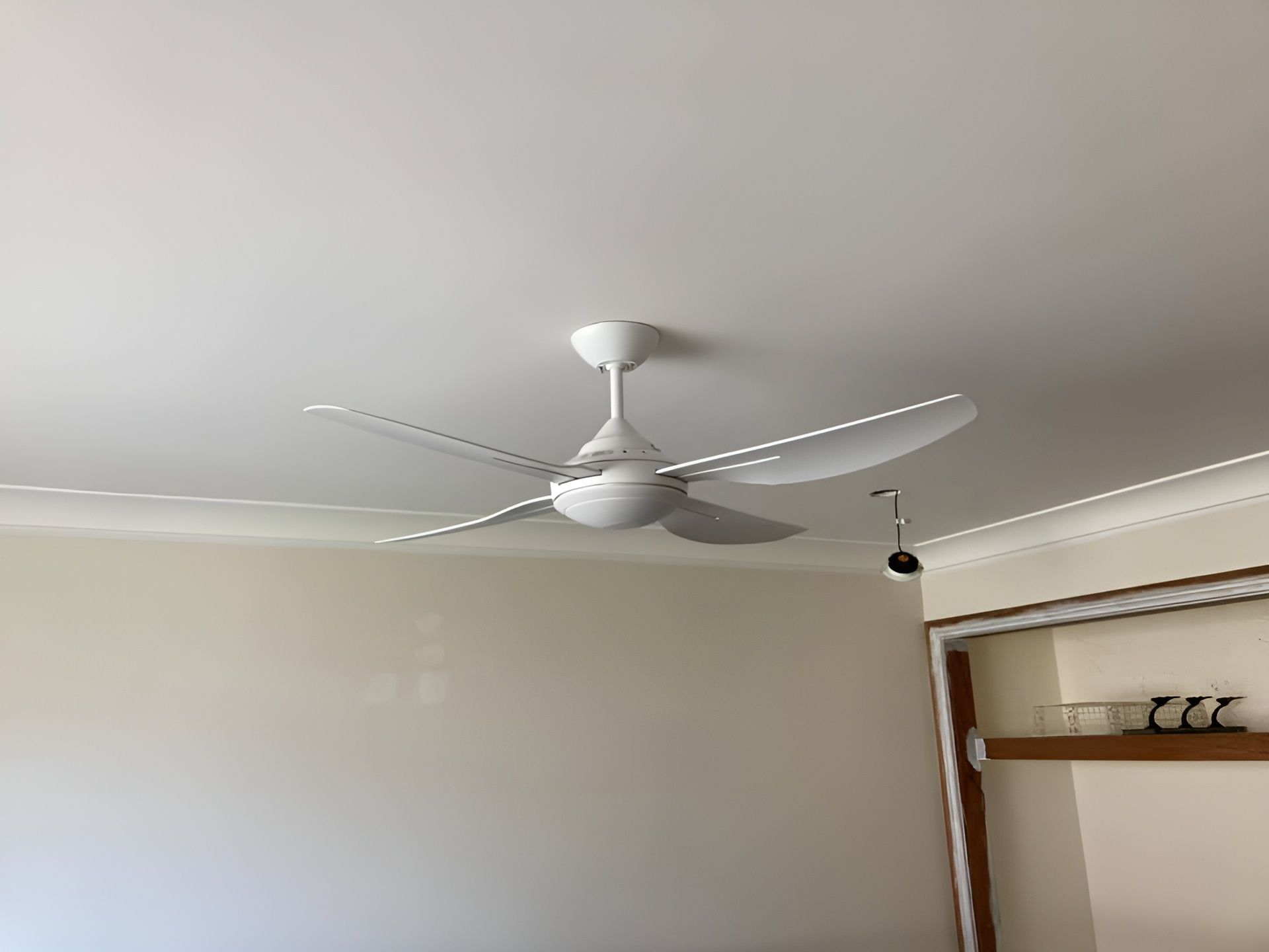 A White Ceiling Fan With Three Blades Against a White Ceiling, Installed in a Room — Neave Electrical in Pacific Palms, NSW