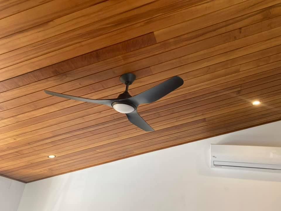 A Ceiling Fan on a Wood-panelled Ceiling, With a White Wall and an Air Conditioning Unit — Neave Electrical in Nabiac, NSW