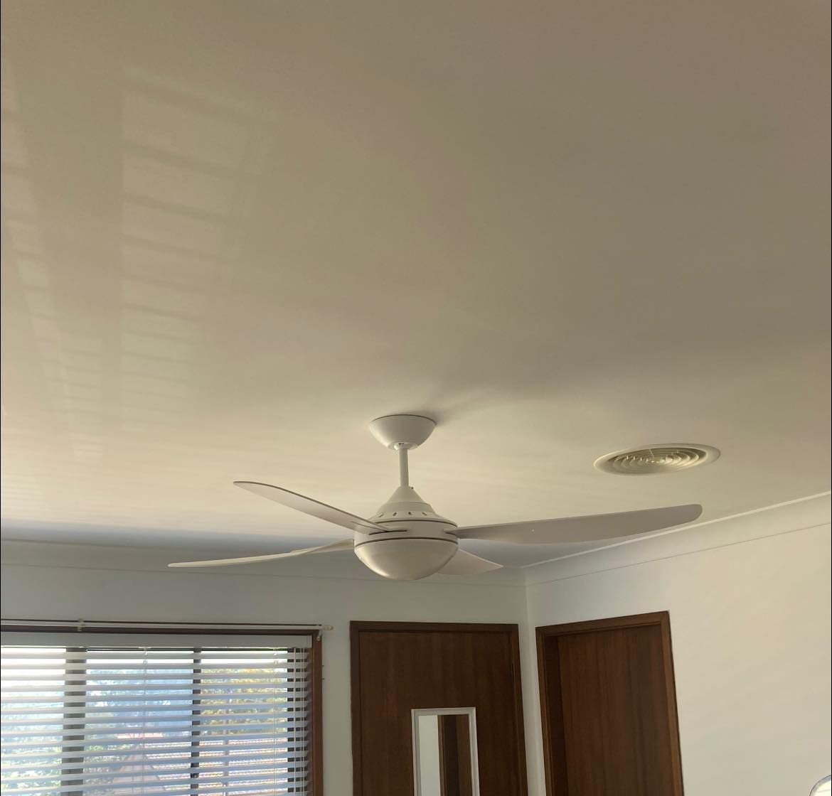 A Ceiling Fan in a White Room, With a Window and Wooden Doors — Neave Electrical in Smiths Lake, NSW