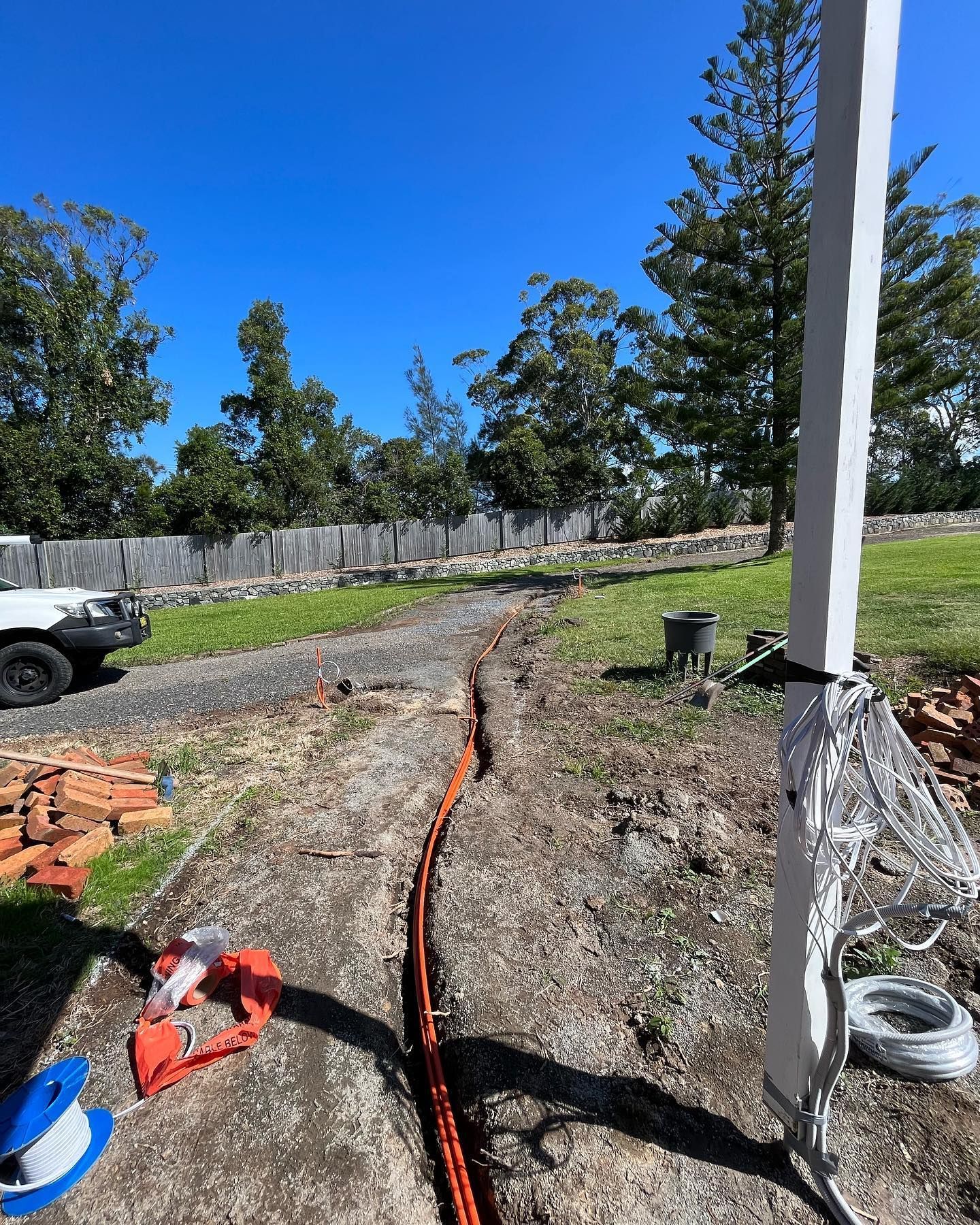 Orange Cables Running Along a Driveway Being Installed — Neave Electrical in Nabiac, NSW