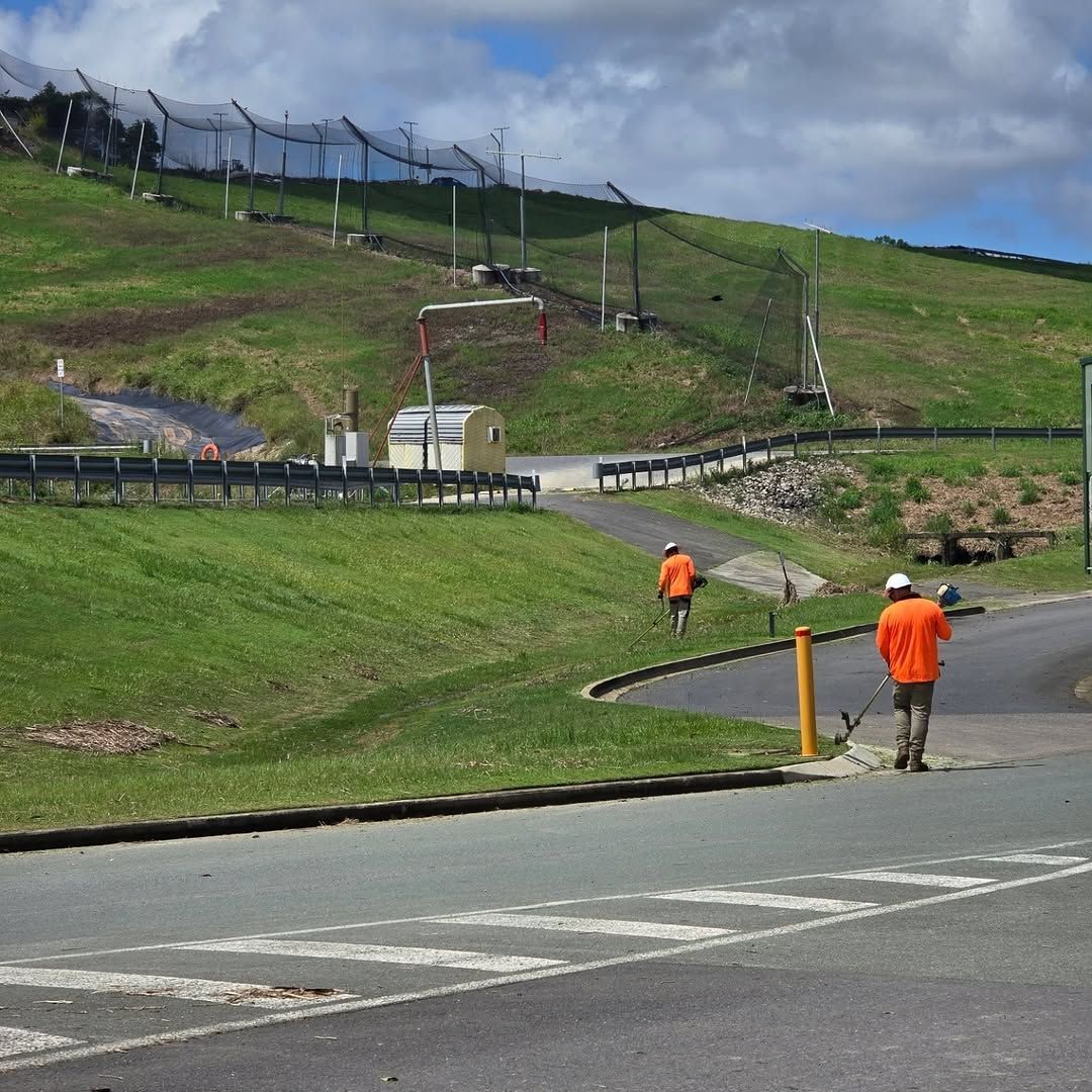 A man in an orange shirt is walking down a road