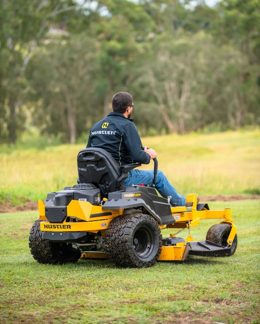 A Man Is Riding A Yellow And Black Lawn Mower On A Lush Green Field — Cairns Mower City In Parramatta Park, QLD