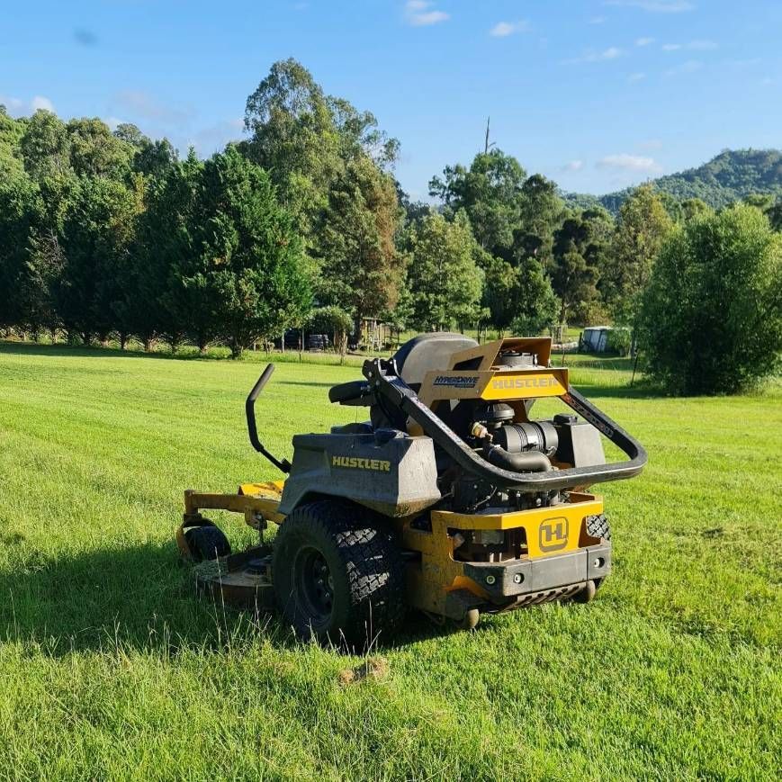 A Yellow And Black Lawn Mower Is Parked In A Grassy Field — Cairns Mower City In Parramatta Park, QLD