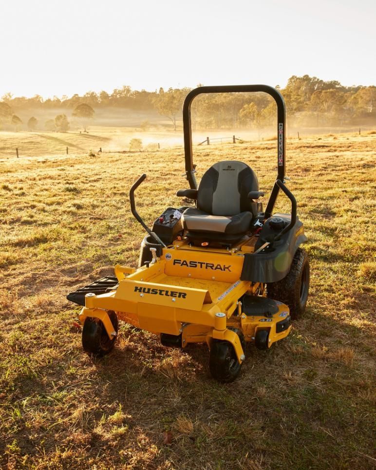 A Yellow Lawn Mower Is Parked In A Grassy Field — Cairns Mower City In Parramatta Park, QLD