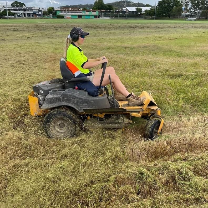 A Woman Is Riding A Lawn Mower In A Field — Cairns Mower City In Parramatta Park, QLD