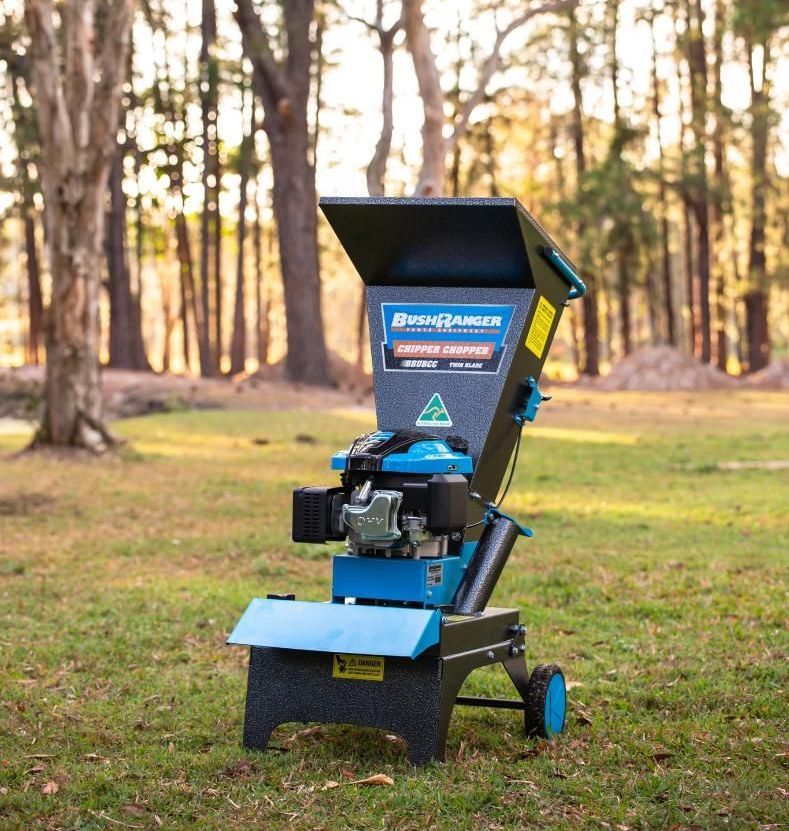 A Blue And Black Shredder Is Sitting In The Grass — Cairns Mower City In Parramatta Park, QLD