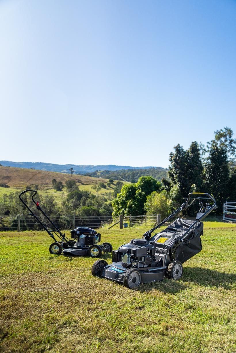 Two Lawn Mowers Are Sitting On Top Of A Lush Green Field — Cairns Mower City In Parramatta Park, QLD