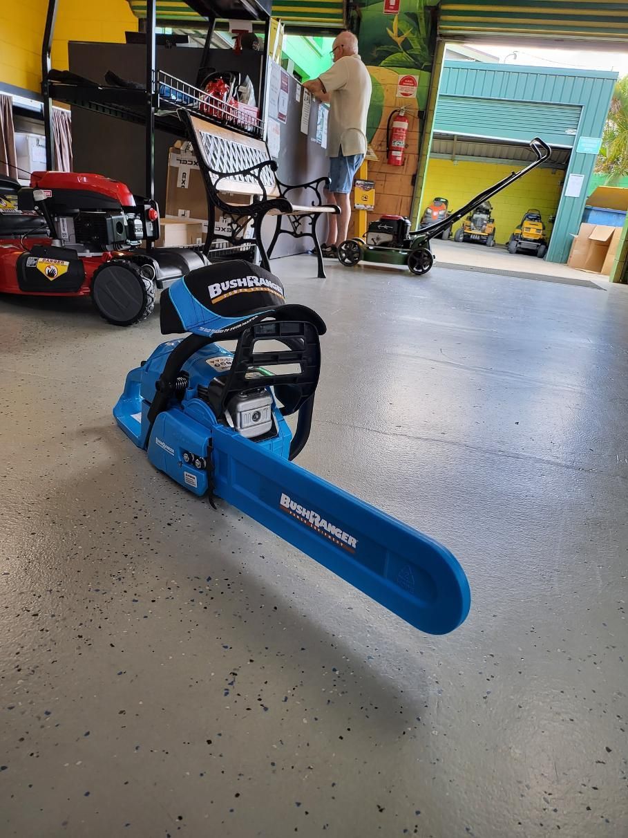 A Blue Chainsaw Is Sitting On The Floor In A Garage — Cairns Mower City In Parramatta Park, QLD