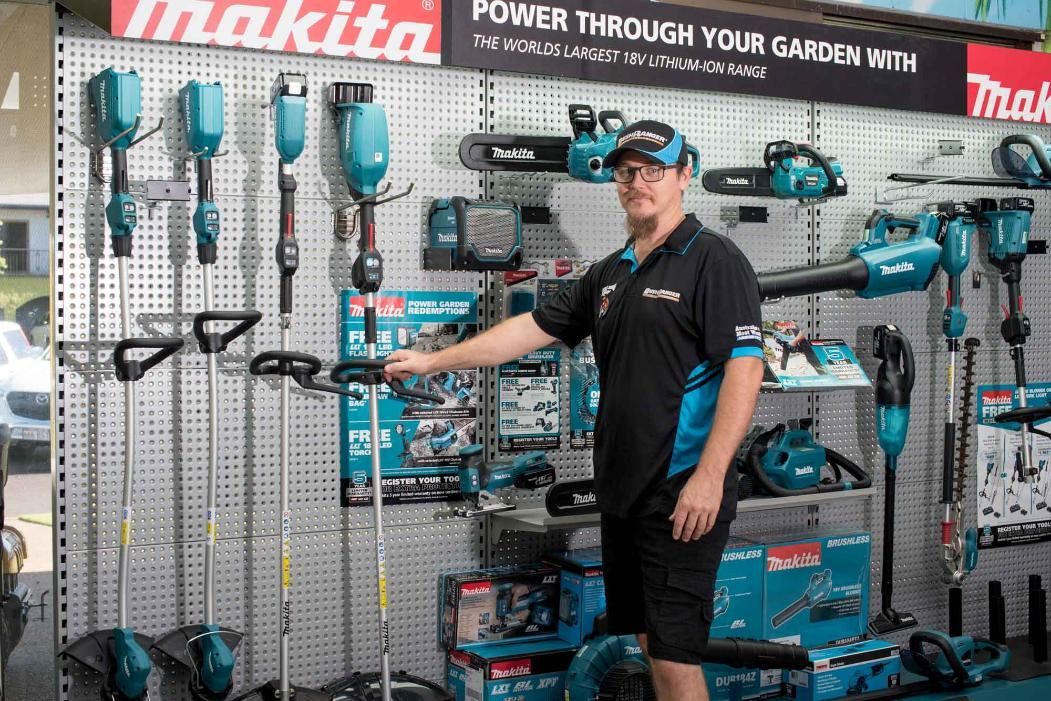 A Man Is Standing In Front Of A Wall Of Makita Tools — Cairns Mower City In Parramatta Park, QLD