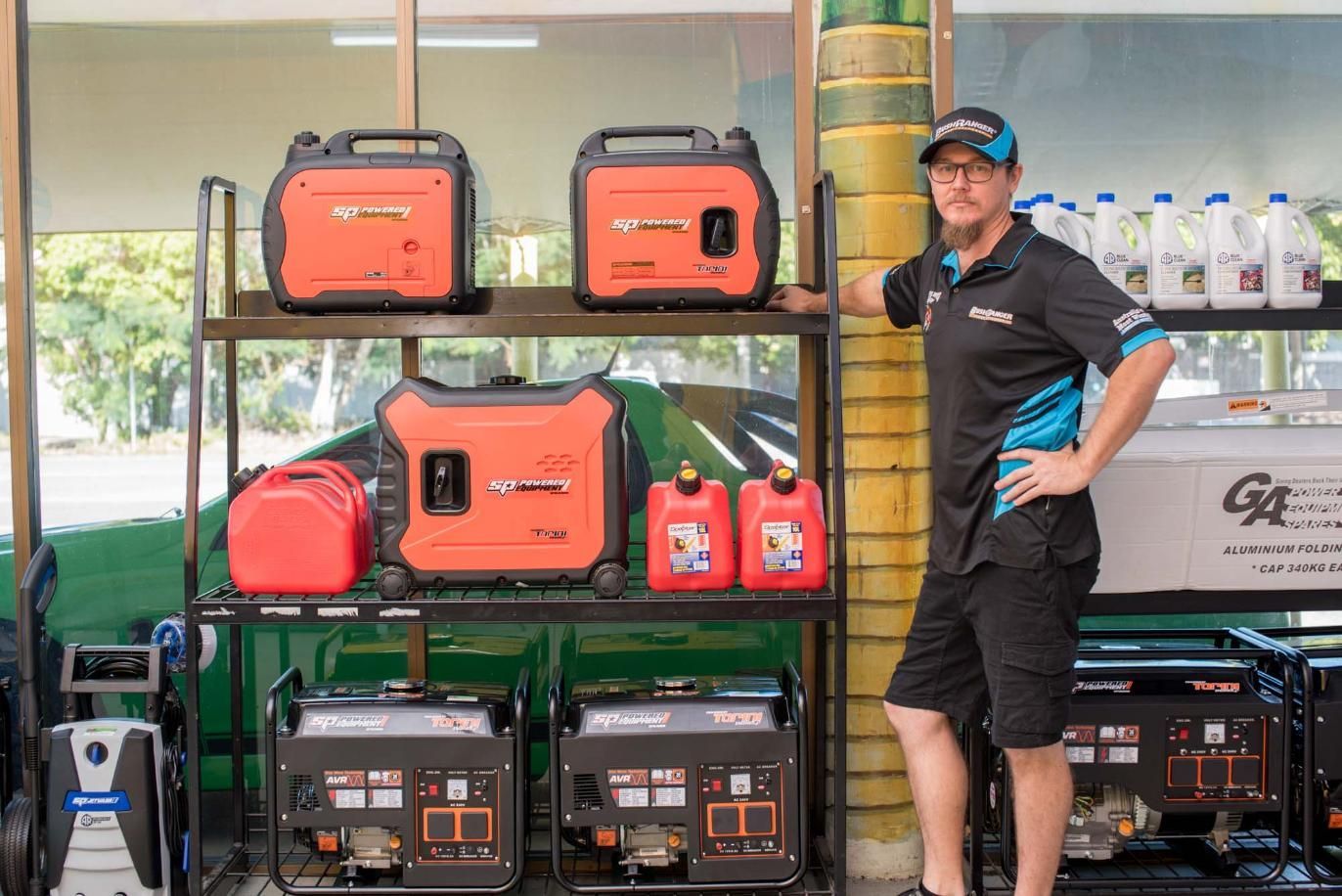 A Man Is Standing In Front Of A Shelf Full Of Generators — Cairns Mower City In Parramatta Park, QLD