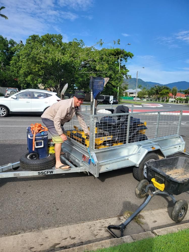 A Man Is Loading A Trailer On The Side Of The Road — Cairns Mower City In Parramatta Park, QLD